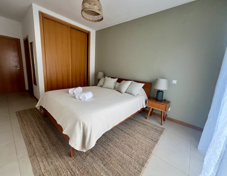 Master bedroom at Casa Solaris with double bed and sage green wall
