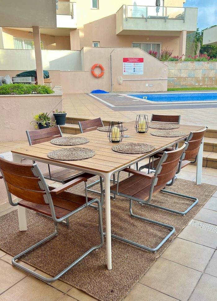 Long teak dining table on the terrace beside the pool at Casa Solaris